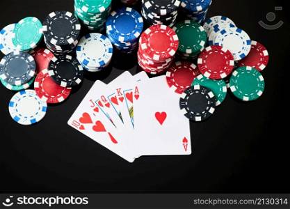 Stack of Casino gambling chips and cards isolated on black reflective background.. Stack of Casino gambling chips and cards isolated on black reflective background