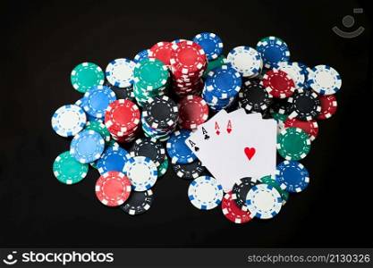Stack of Casino gambling chips and cards isolated on black reflective background.. Stack of Casino gambling chips and cards isolated on black reflective background