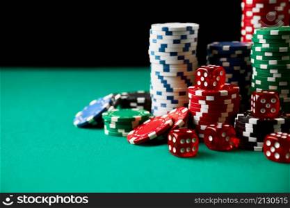 Stack of Casino gambling chips and dices on green table.. Stack of Casino gambling chips and dices on green table