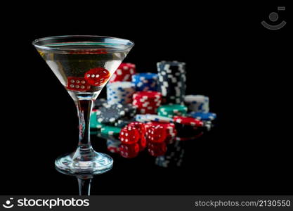 Stack of Casino gambling chips, glass of martini vermouth and red dices isolated on reflective black background.. Stack of Casino gambling chips, glass of martini vermouth and red dices isolated on reflective black background