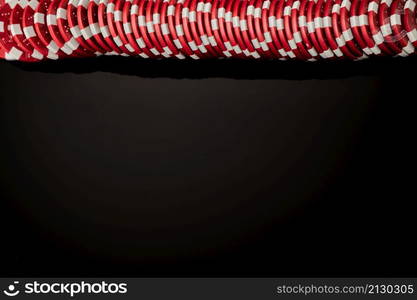 Stack of Casino gambling chips isolated on black reflective background.. Stack of Casino gambling chips isolated on black reflective background