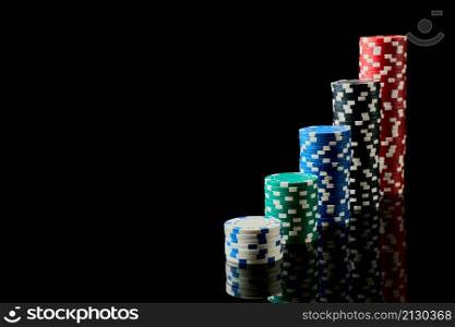 Stack of Casino gambling chips isolated on black reflective background.. Stack of Casino gambling chips isolated on black reflective background