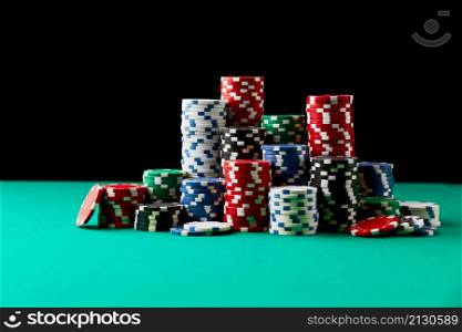 Stack of Casino gambling chips on green table.. Stack of Casino gambling chips on green table