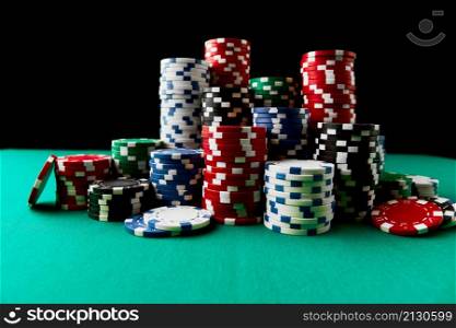 Stack of Casino gambling chips on green table.. Stack of Casino gambling chips on green table