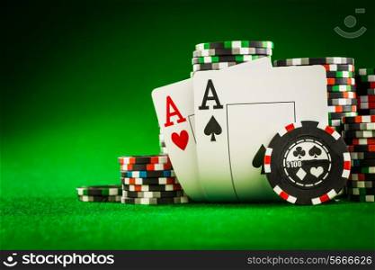 Stack of chips and two aces on the table on the green baize - poker game concept
