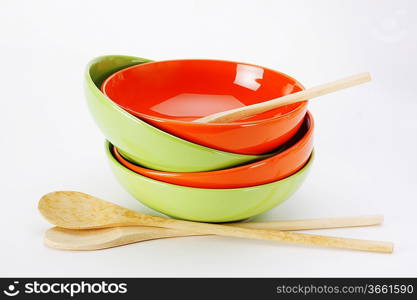 stack of clean empty plates and wooden spoons on white background