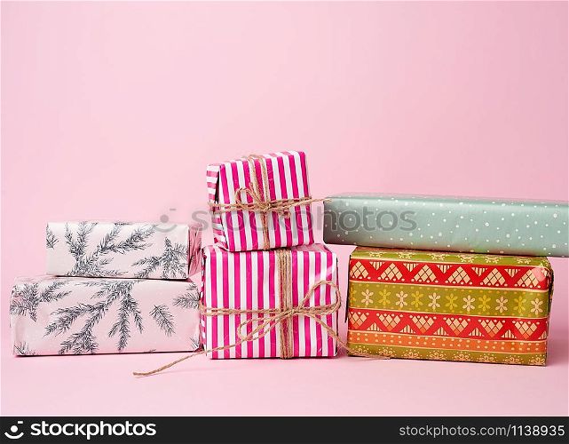stack of colored paper wrapped gift boxes. great design for any purposes. pink background