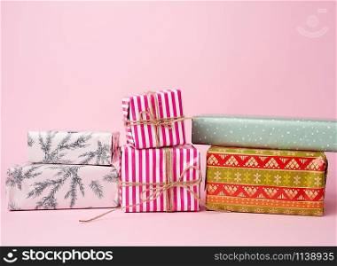 stack of colored paper wrapped gift boxes. great design for any purposes. pink background