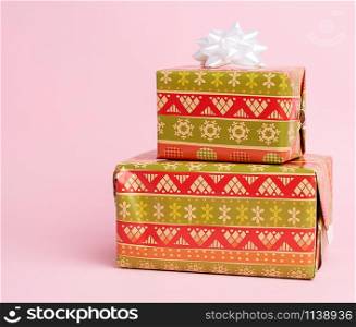 stack of colored paper wrapped gift boxes. great design for any purposes, pink background