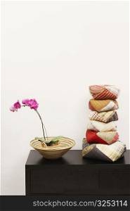 Stack of cushions and a potted plant on a cabinet