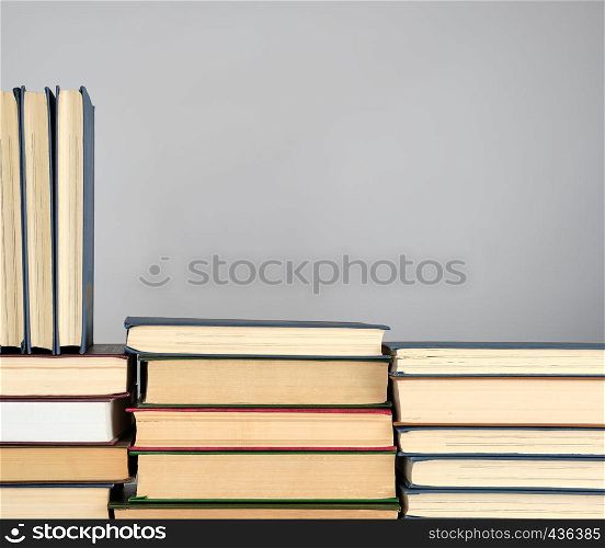 stack of different books on a gray background, copy space