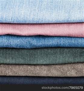 stack of different jeans and corduroys close up
