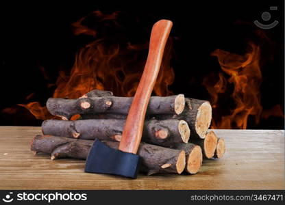 stack of firewood logs and axe on a wooden surface