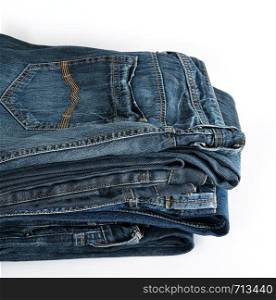 stack of folded blue jeans on a white background, close up