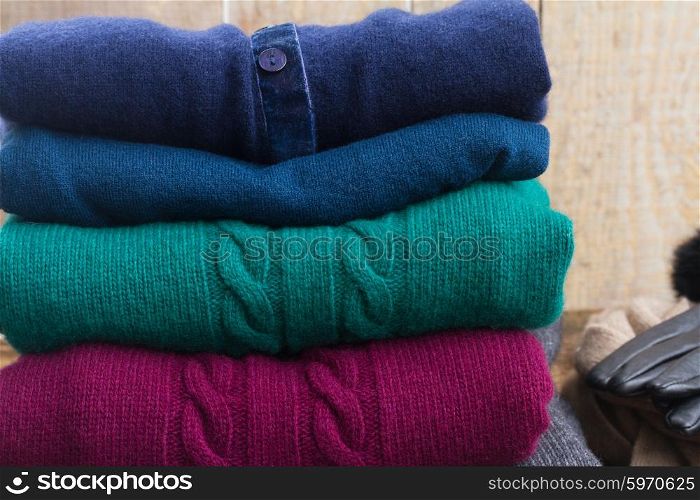 stack of folded woolen green, blue and red clothes