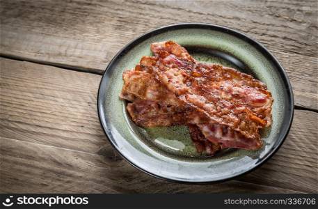 Stack of fried bacon strips on the plate
