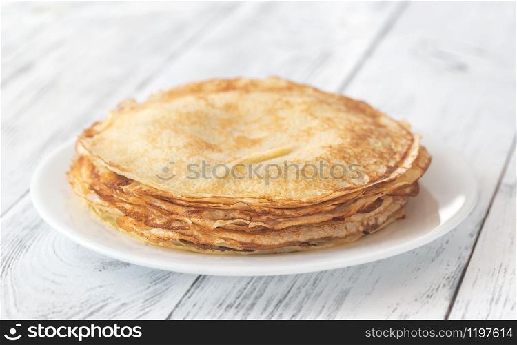 Stack of homemade crepes on the white plate