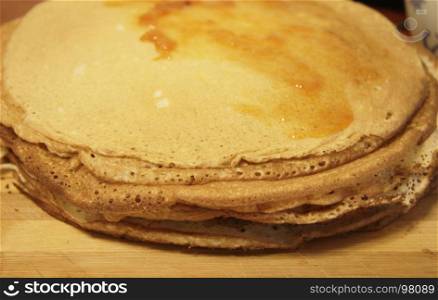 Stack of homemade pancakes on wood cooking board