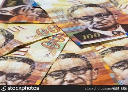 Stack of Israeli money bills of 100 shekel.