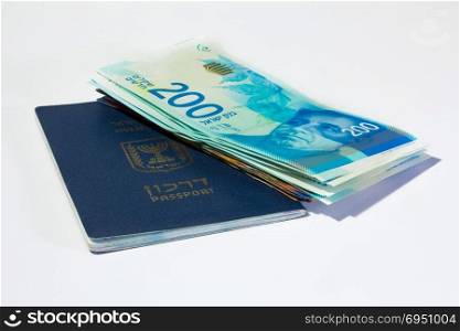 Stack of israeli money bills of 200 shekel and israeli passport.
