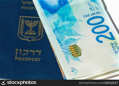Stack of israeli money bills of 200 shekel and israeli passport - Top view.