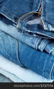 Stack of jeans in different colors with a snake on top