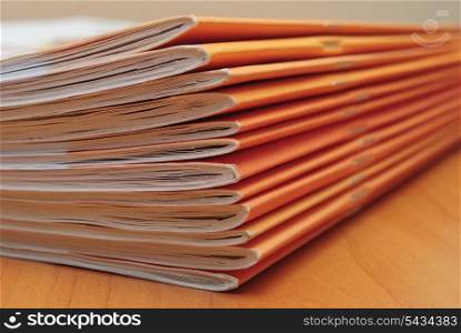 Stack of journals on office desktop. Shallow deep of field
