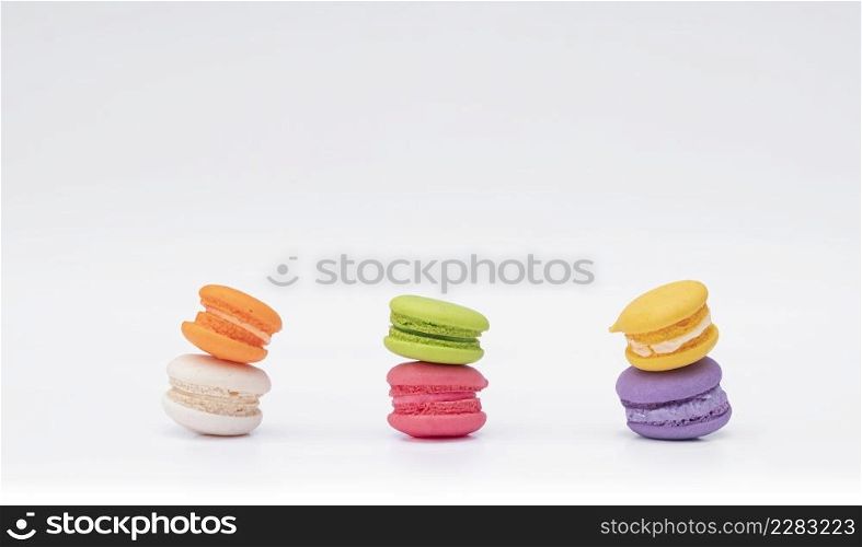 Stack of mini colorful various tasty macarons on white background
