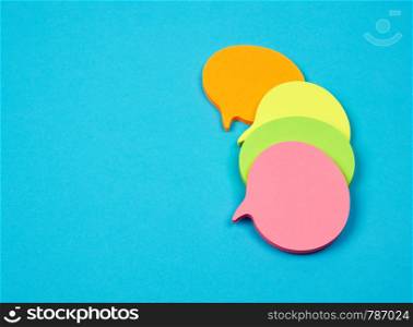 stack of multicolored empty paper stickers in the form of clouds on a blue background