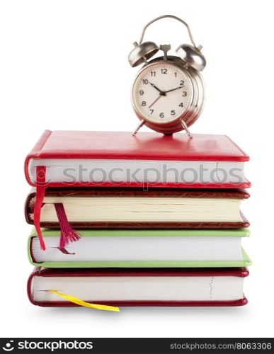 Stack of notebooks with bookmarks and alarm clock isolated on white background. Stack of notebooks with bookmarks and alarm clock