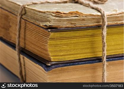 stack of old books tied with rope isolated on white