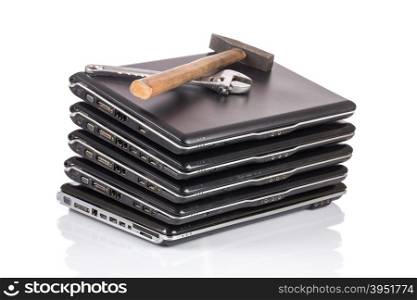 stack of old laptops awaiting repair isolated on white background