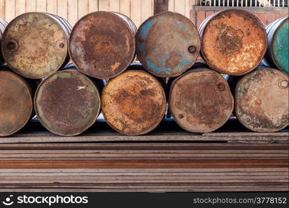 Stack of old rusty gas tank on stack of plank