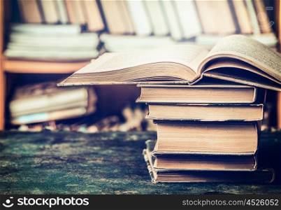Stack of open books on aged table in the library, side view