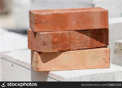 Stack of orange bricks on construction site. Renovation, building objects and details concept.. Stack of orange bricks on construction site