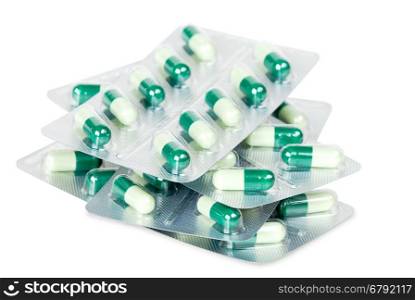 stack of packs of green pills on a white background