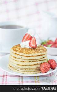 Stack of pancakes decorated with ripe raspberries and sour cream close-up
