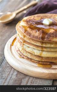 Stack of pancakes with butter and maple syrup