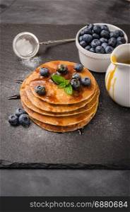 Stack of pancakes with fresh blueberry and caramel syrup.