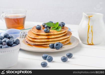 Stack of pancakes with fresh blueberry and caramel syrup.