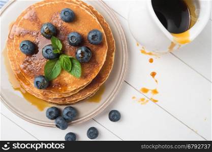 Stack of pancakes with fresh blueberry and caramel syrup. Top view