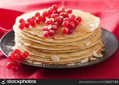 stack of pancakes with redcurrant and powder sugar