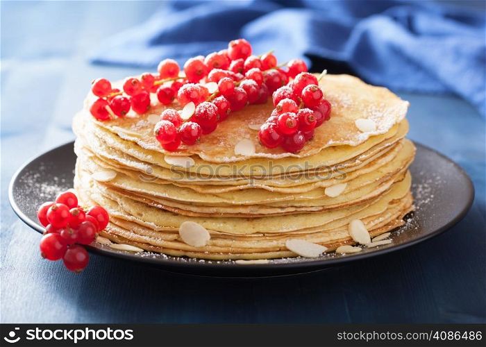 stack of pancakes with redcurrant and powder sugar