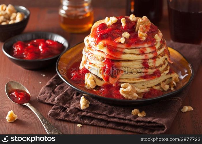 stack of pancakes with strawberry jam and walnuts. tasty dessert