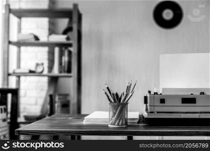 Stack of paper and vintage old typewriter at wooden desk table. Writer or screenwriter creative concept