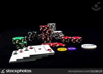 Stack of poker chips and poker cards on black background