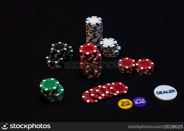Stack of poker chips on black background, poker chips spread, big blind, dealer, poker concept.