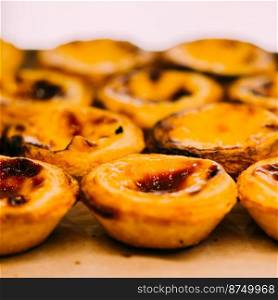 Stack of Portuguese egg tart also known as Pasteis de Nata on display in front of shop - selective focus. Stack of Portuguese egg tart also known as Pasteis de Nata on display in front of shop