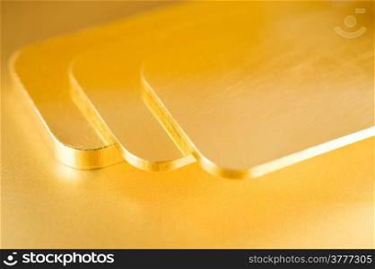 stack of pure gold ingots on a golden background