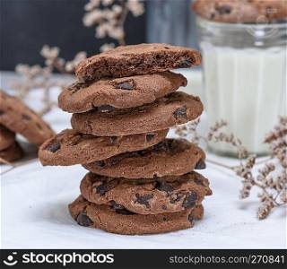 stack of round chocolate cookies and milk, close up